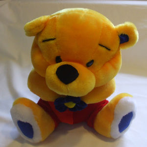 Yellow Teddy Bear With Red Pants Holding Flower